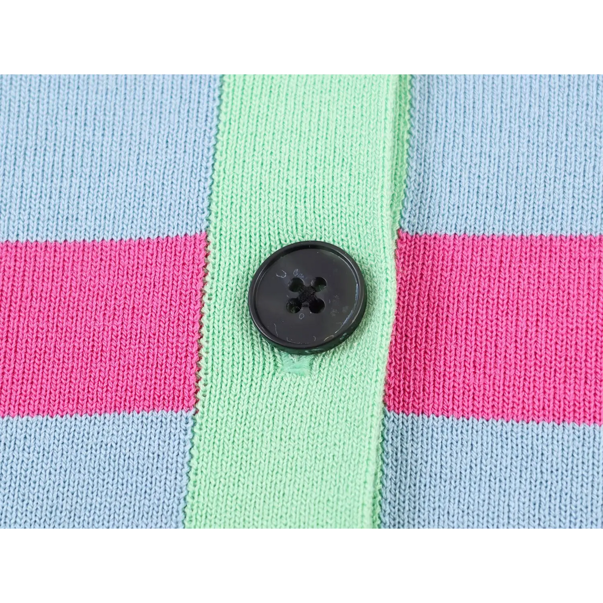 Close-up of black four-hole round button on mint green placket of striped cardigan