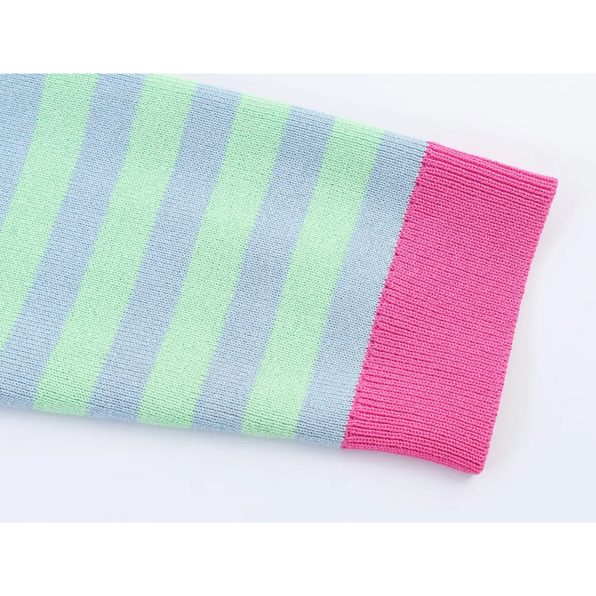 Close-up of rosy pink ribbed cuff on blue and green striped knit sleeve