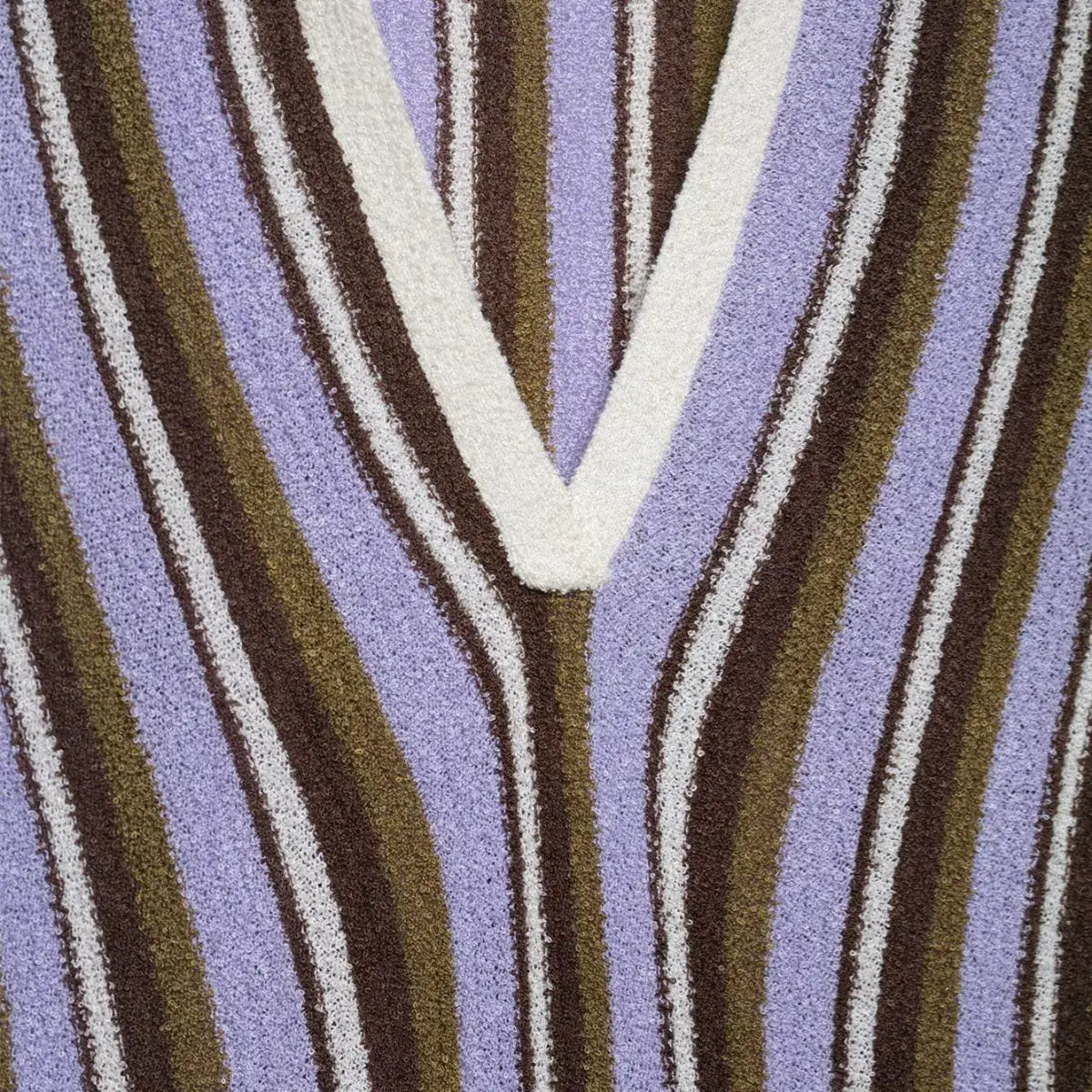 Close-up of the V-neckline on the striped knit mini dress, showing the contrast white trim and multi-color stripe pattern
