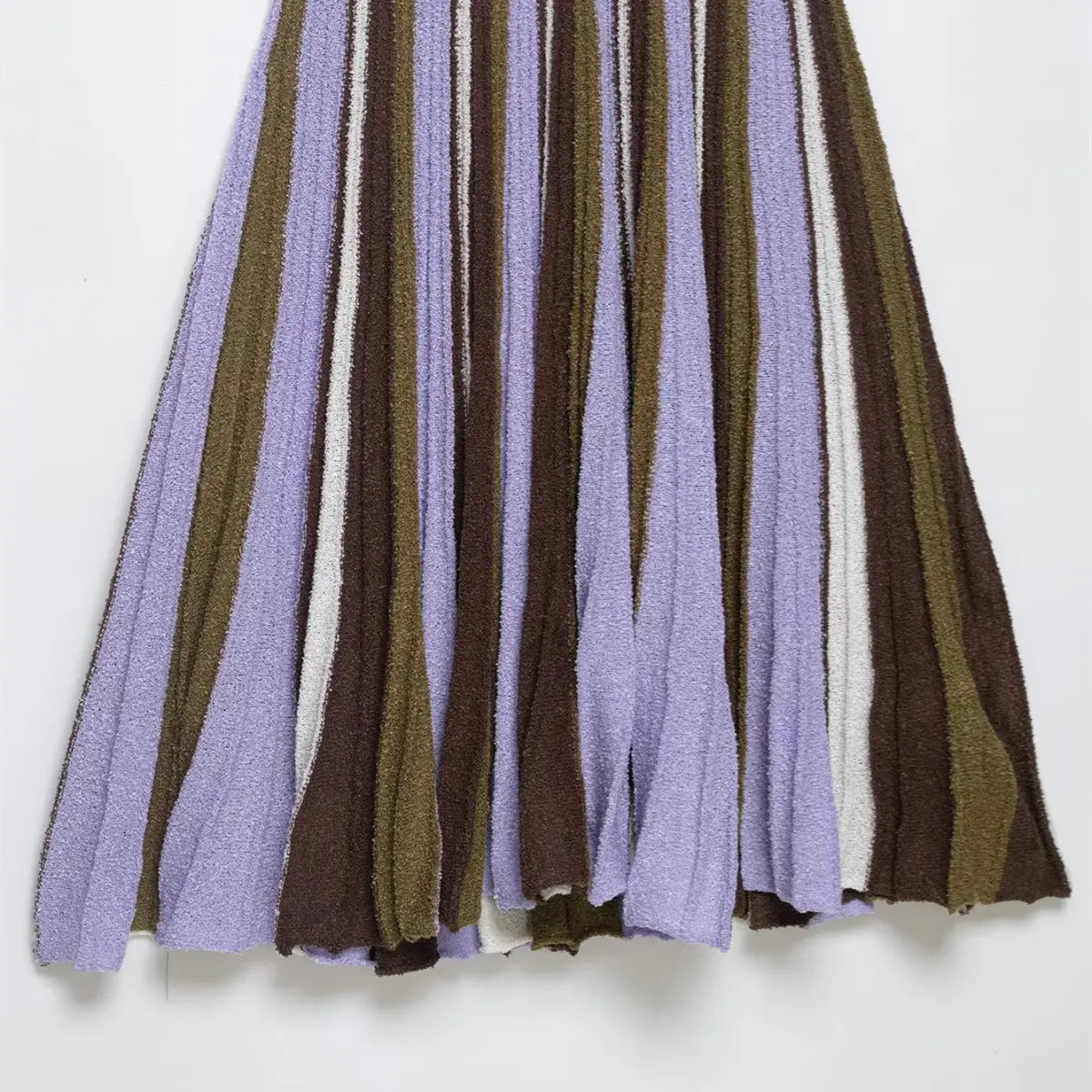 Close-up of the pleated skirt on the striped knit mini dress, showing the flared silhouette and multi-color stripes
