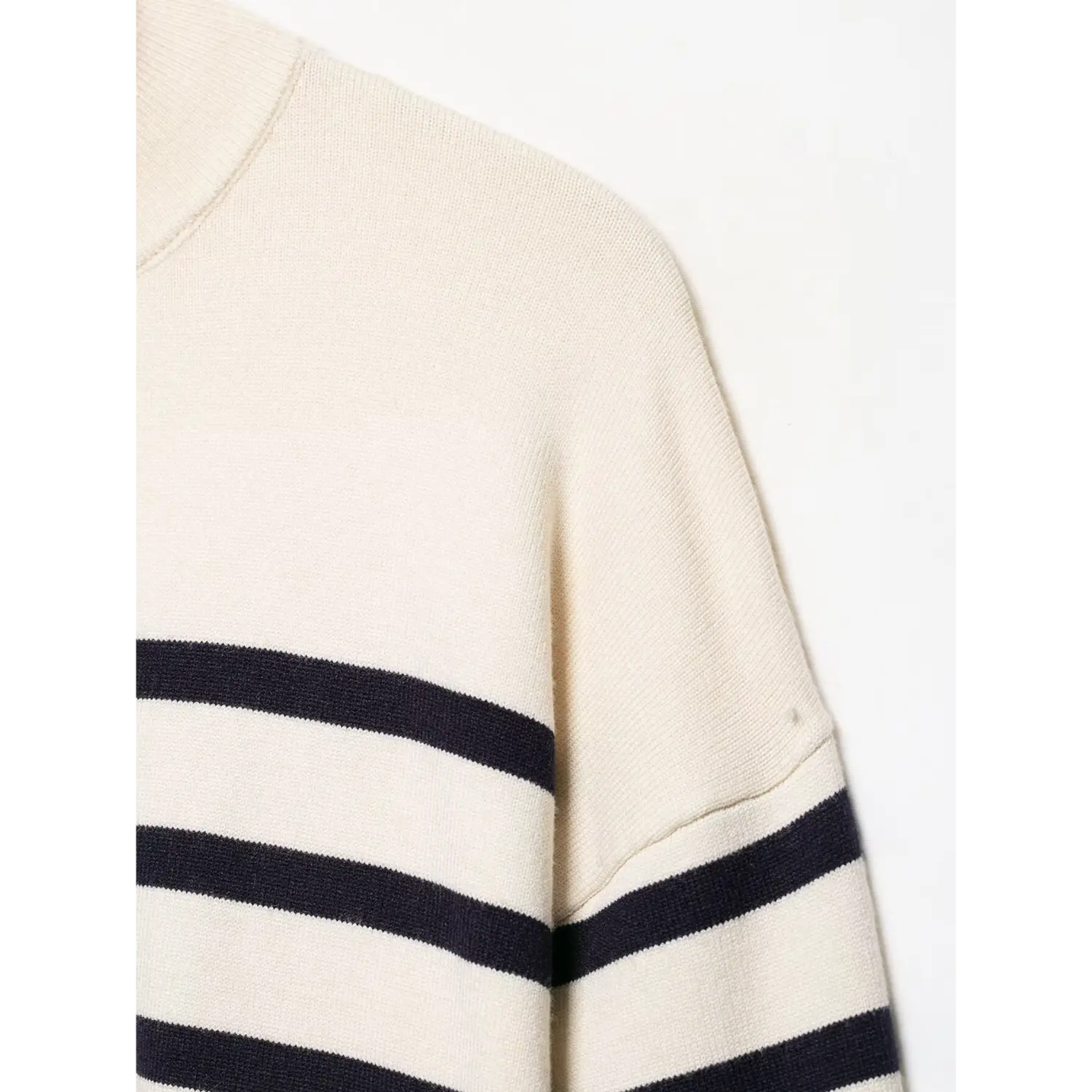 Shoulder and sleeve seam close‑up, soft cream navy stripe knit texture