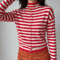 Model wearing red and cream striped knit cardigan with pearl necklace
