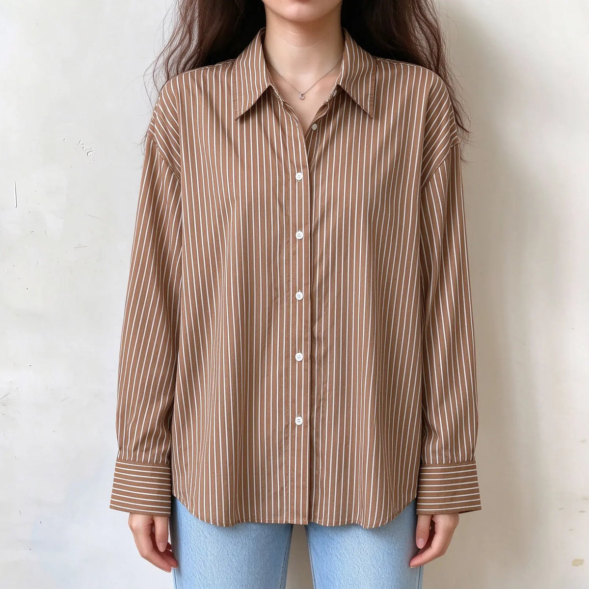 Model wearing striped point collar button down oversized shirt with jeans, front view