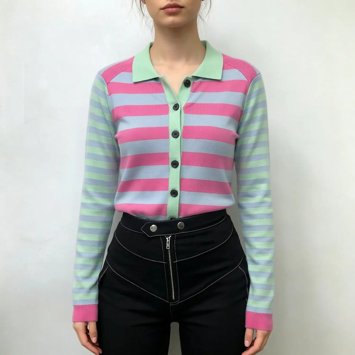Model wearing striped knit cardigan with polo collar and black high-waisted trousers