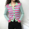 Model wearing pink blue striped knit cardigan with black pants on white background