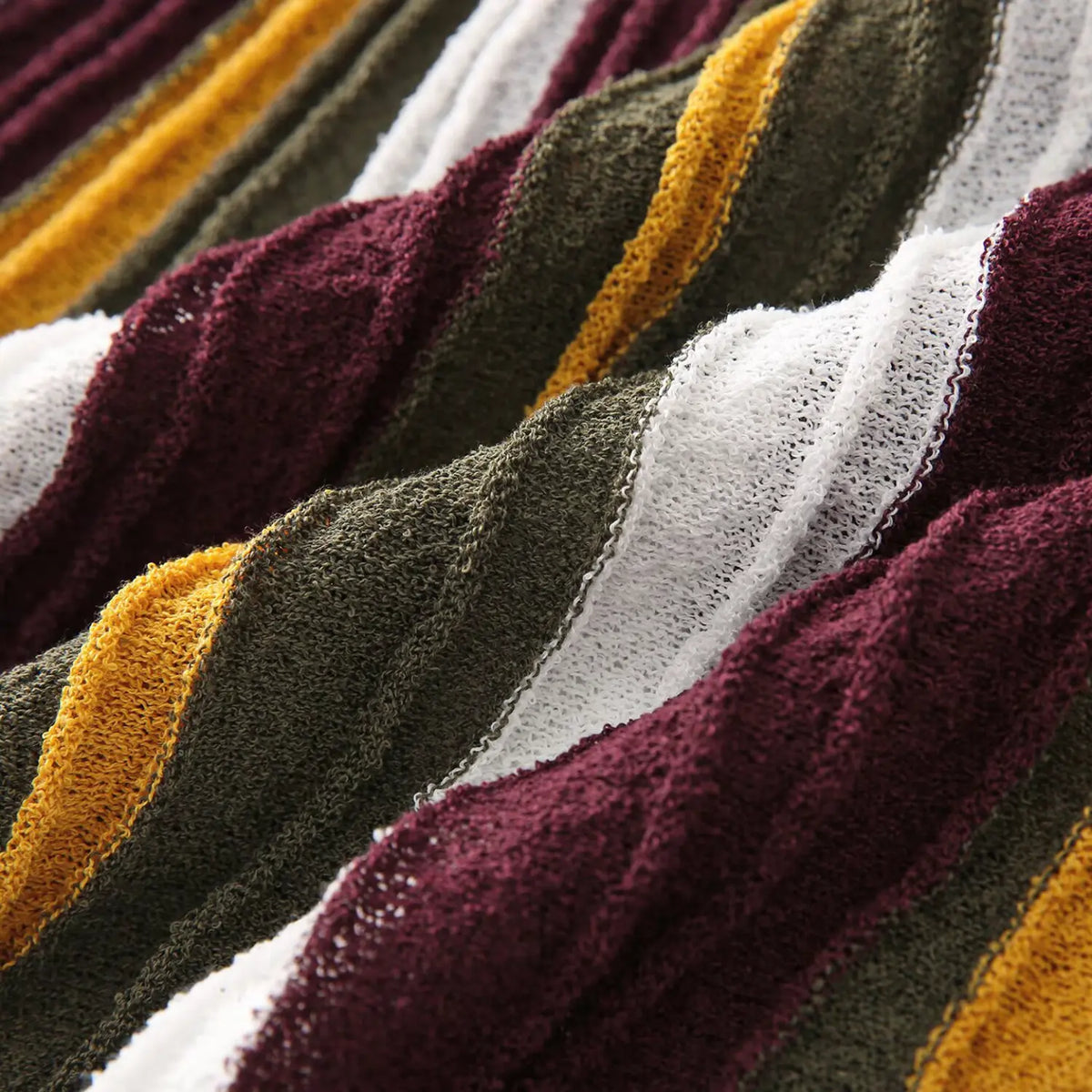 Close-up of burgundy olive striped fabric drape and pile