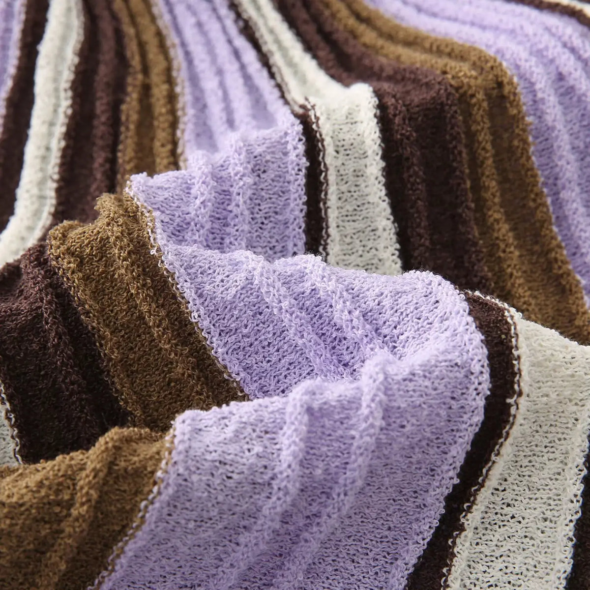 Close-up of lavender brown striped fabric drape and pile