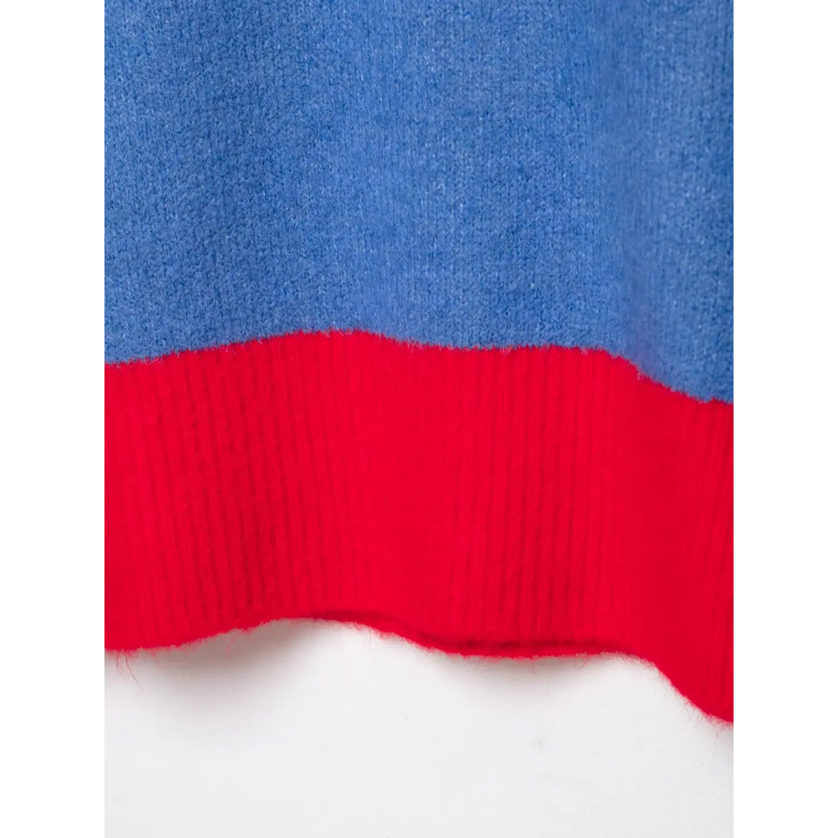 Close-up of blue knit fabric joined with red ribbed knit trim