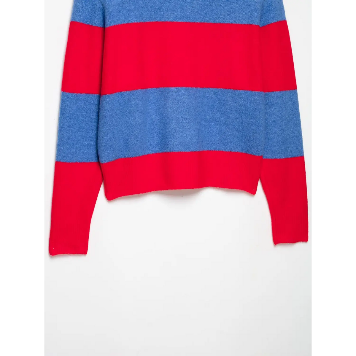 Close-up of blue and red horizontal stripes with red ribbed cuff and hem on knit top