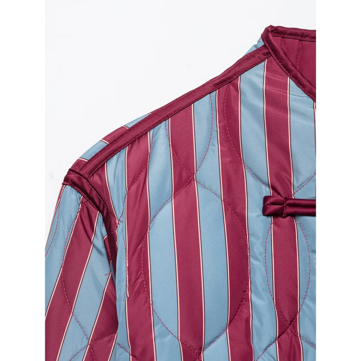 Close-up of mandarin collar and shoulder on striped quilted jacket