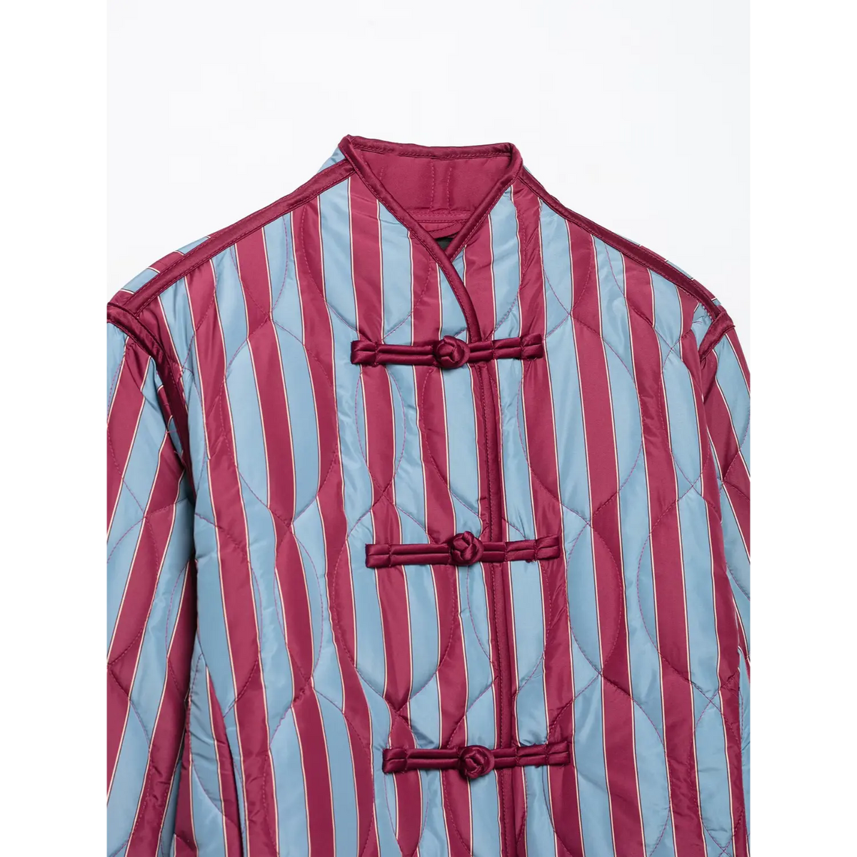 Close-up of mandarin collar with four frog knot buttons on striped quilted jacket
