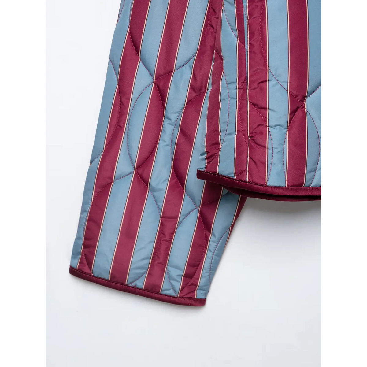 Close-up of wine binding hem and cuff on striped quilted jacket