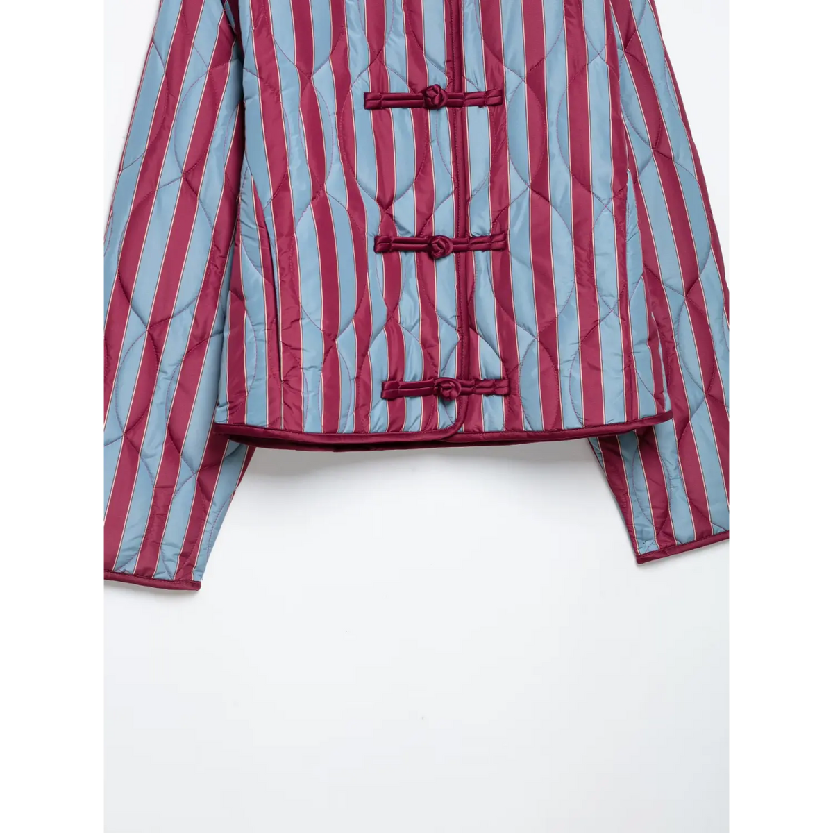 Close-up of lower frog buttons and hem on striped quilted jacket