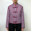 Model wearing striped quilted jacket with mandarin collar and black trousers