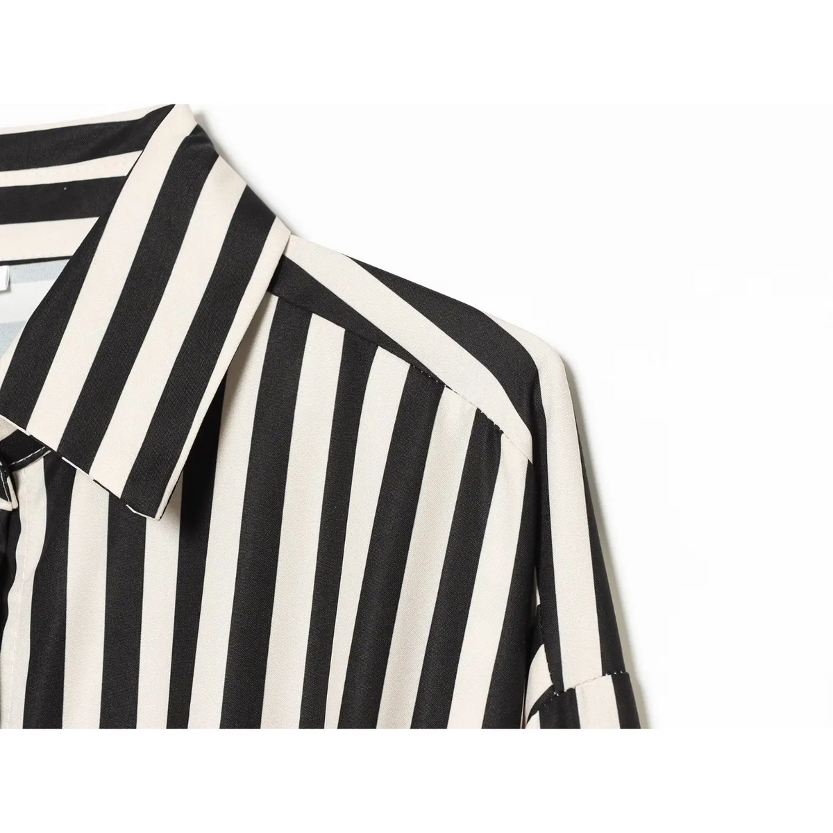 Partial close‑up of point collar and shoulder seam, black cream vertical stripe woven fabric, neat stitching detail