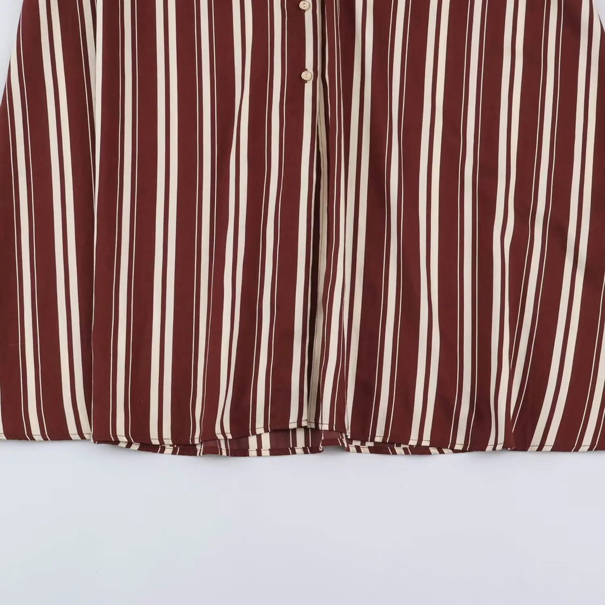 Partial view of front button placket and flowy skirt on burgundy cream stripe maxi dress