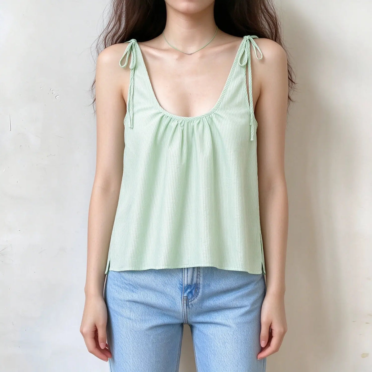 Model wearing striped tie shoulder gathered cami top with jeans, front view
