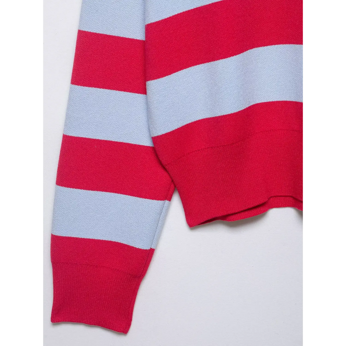 Close-up of red ribbed hem and cuff with stripe pattern