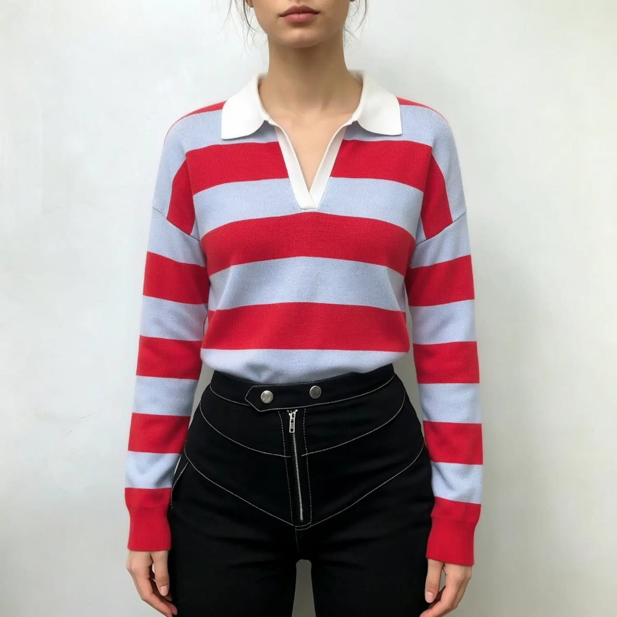 Model wearing striped V neck collared knit top with black high waist trousers