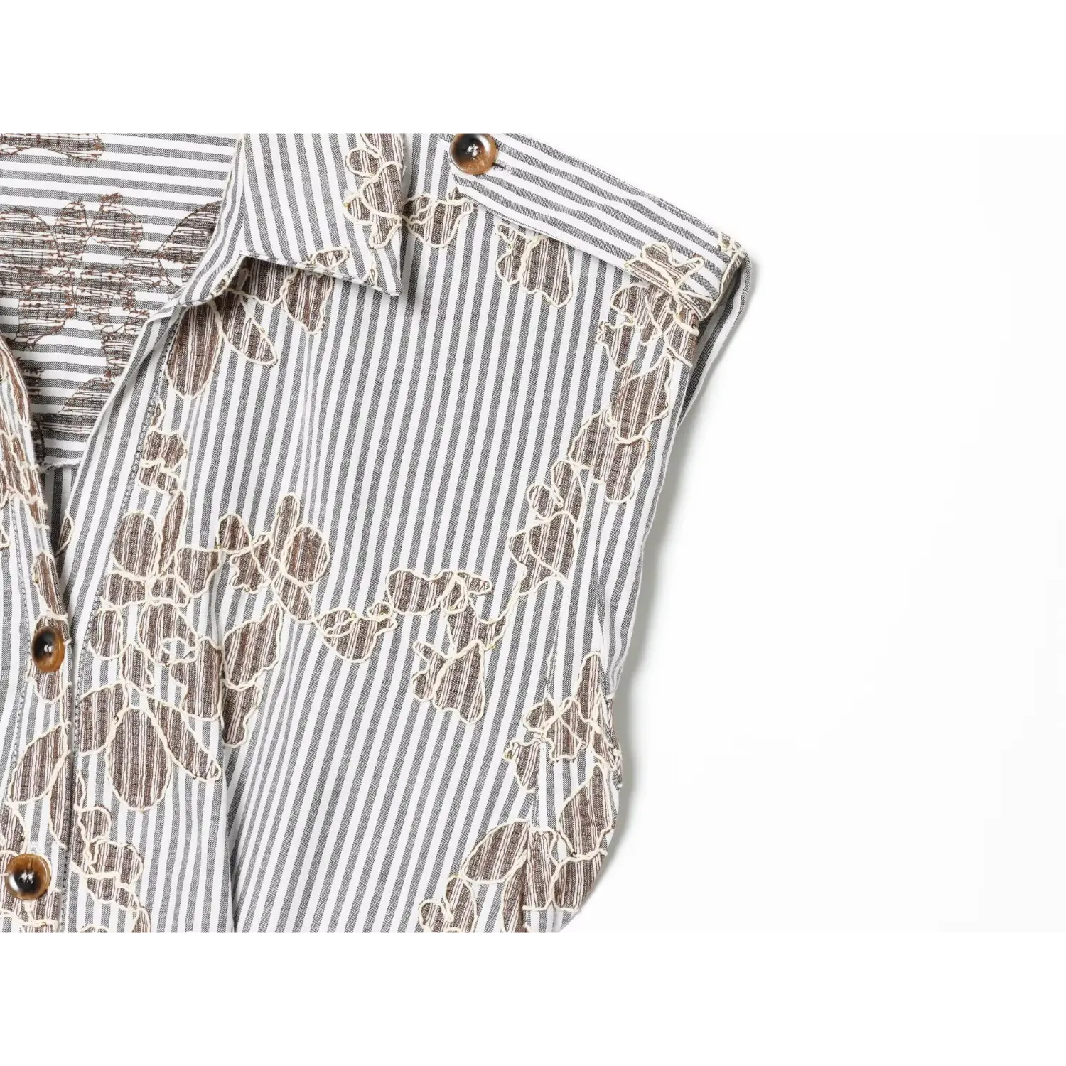 Close‑up armhole stitching and mixed stripe floral embroidered fabric texture