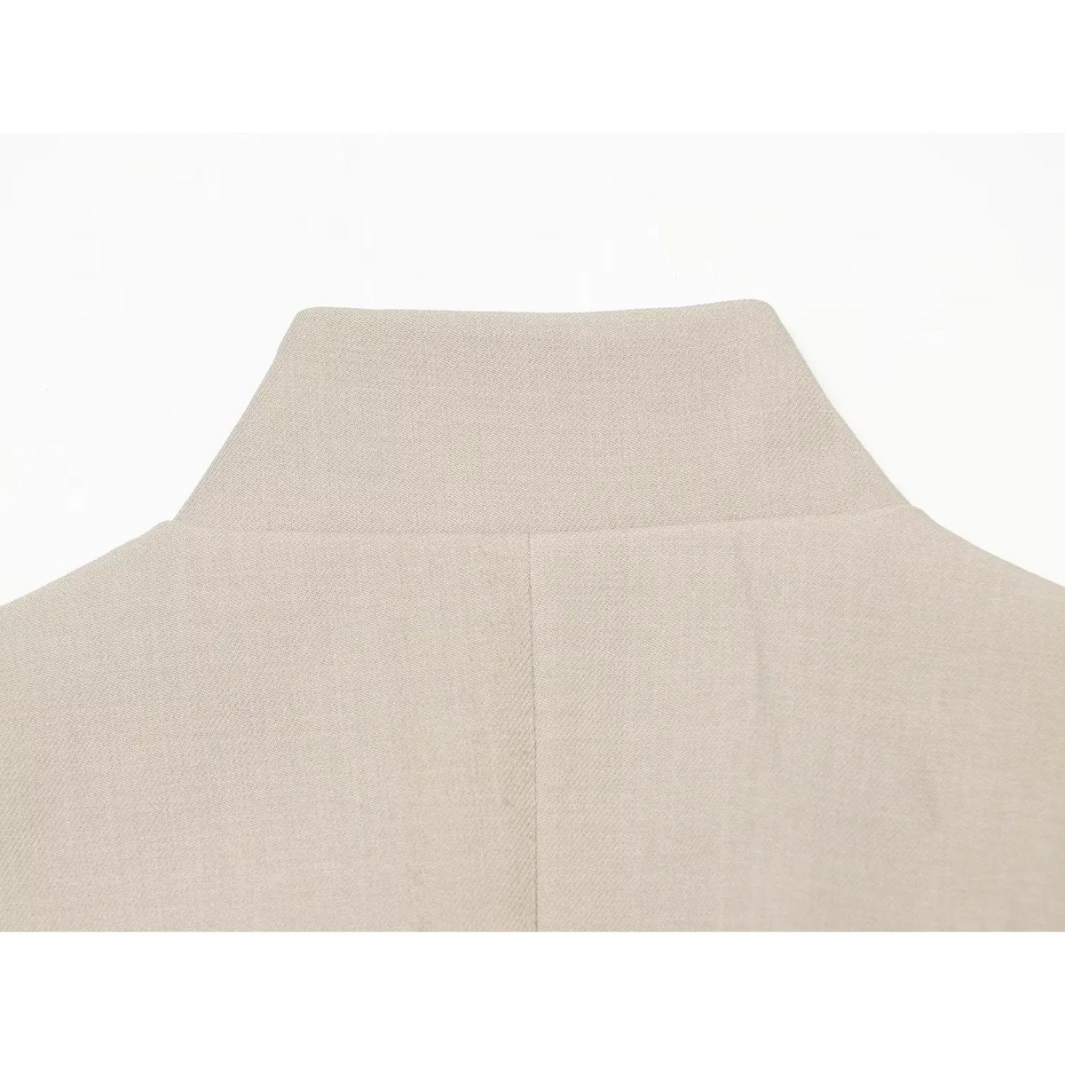 Close‑up of high stand collar and center back seam of beige sleeveless blazer