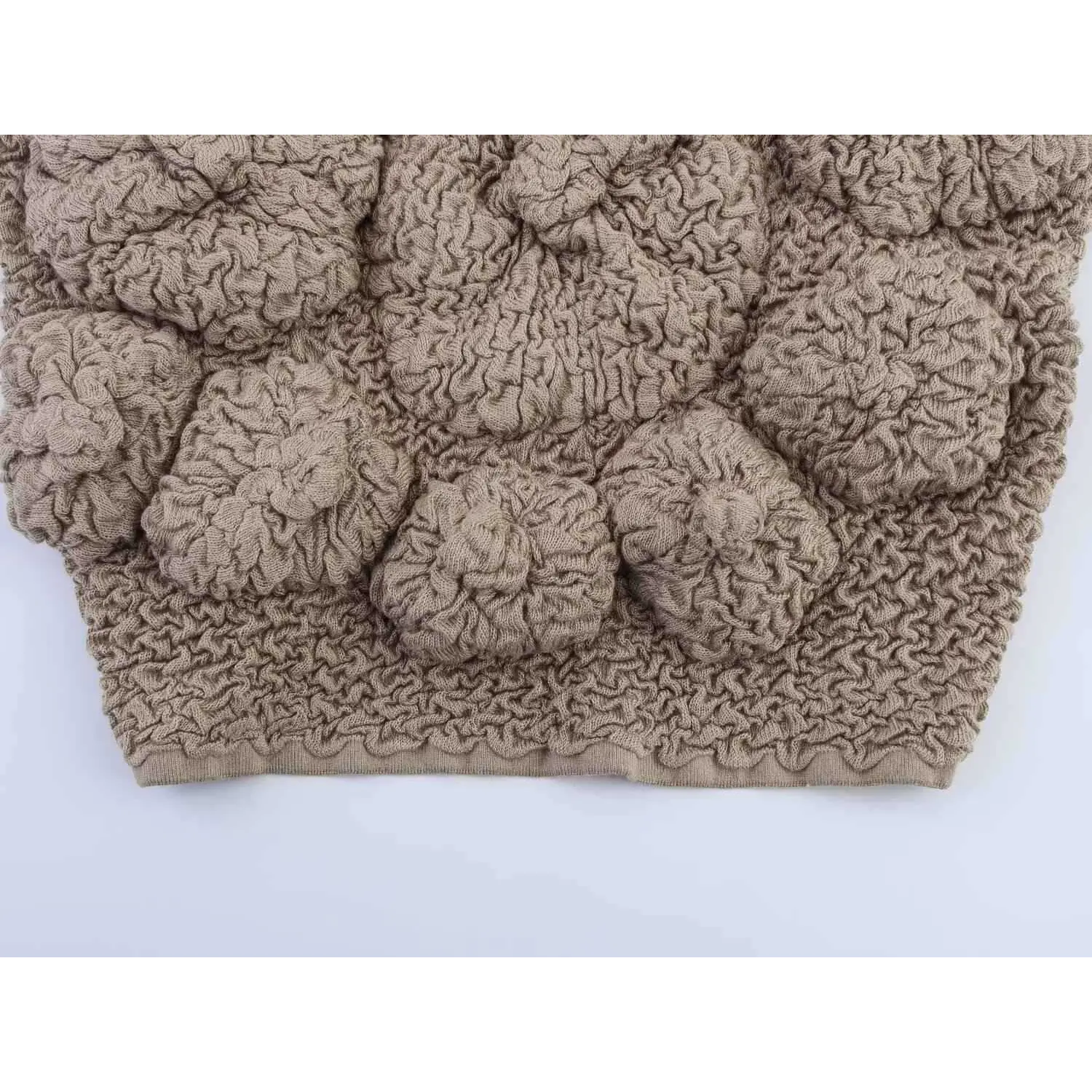 Macro shot of the raised floral bubble knit texture on the front of taupe camisole top