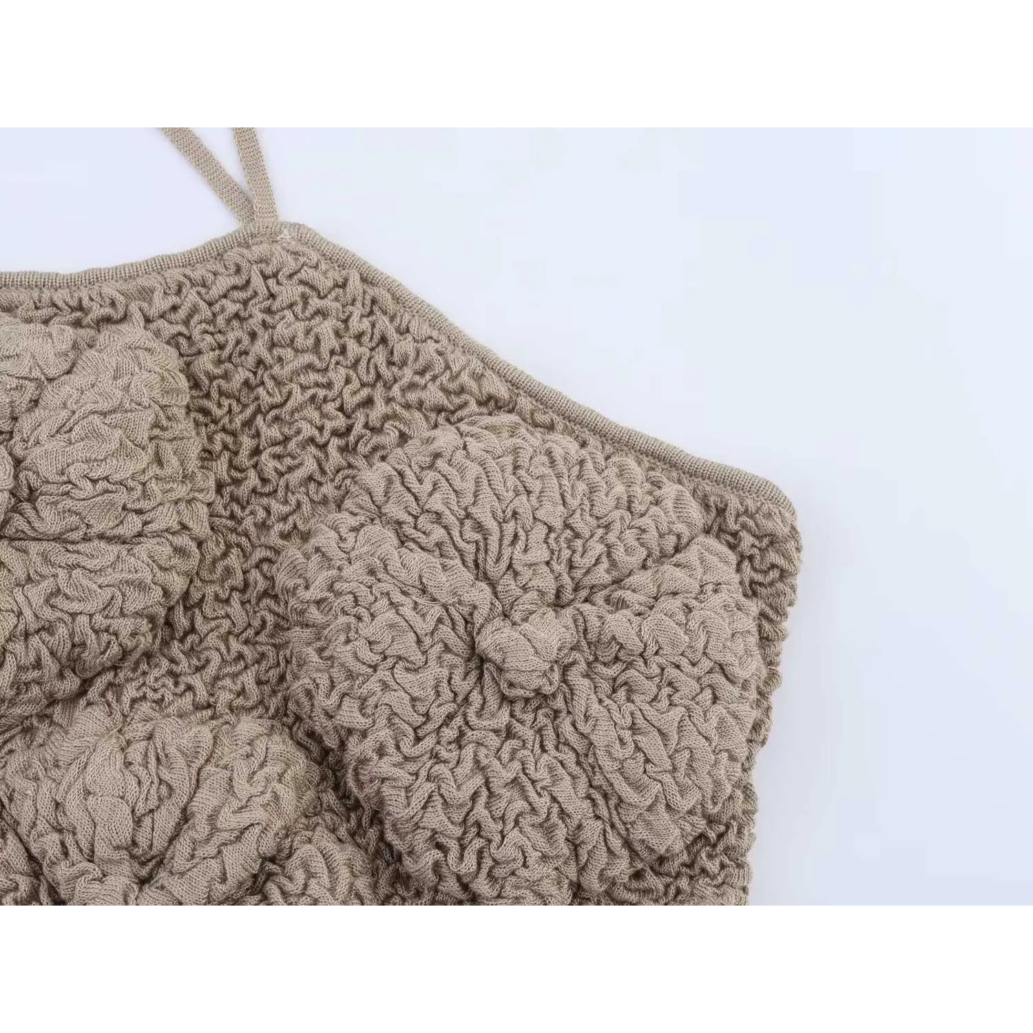 Close-up detail of textured bubble knit fabric on the side panel of taupe camisole top