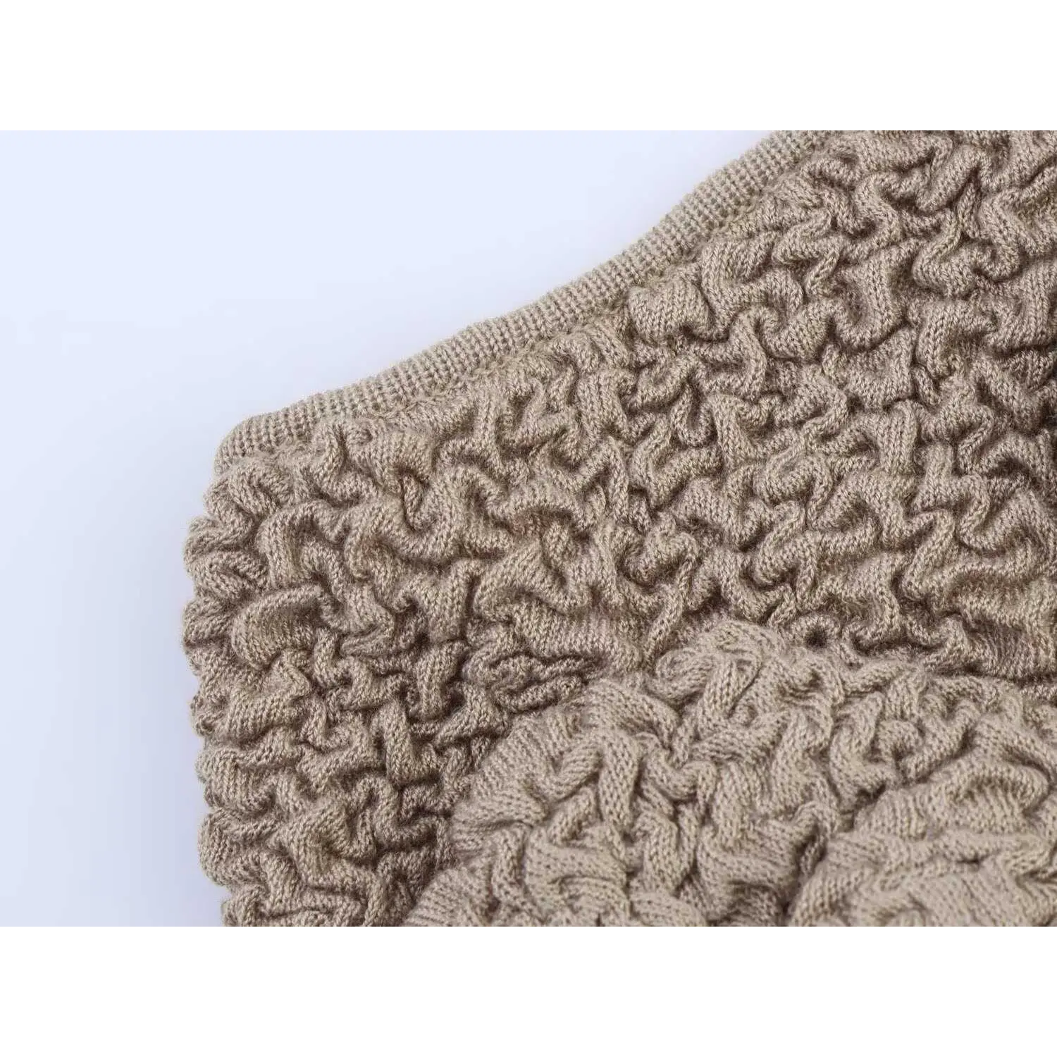 Close-up detail of the edge stitching and textured bubble knit fabric on taupe camisole top