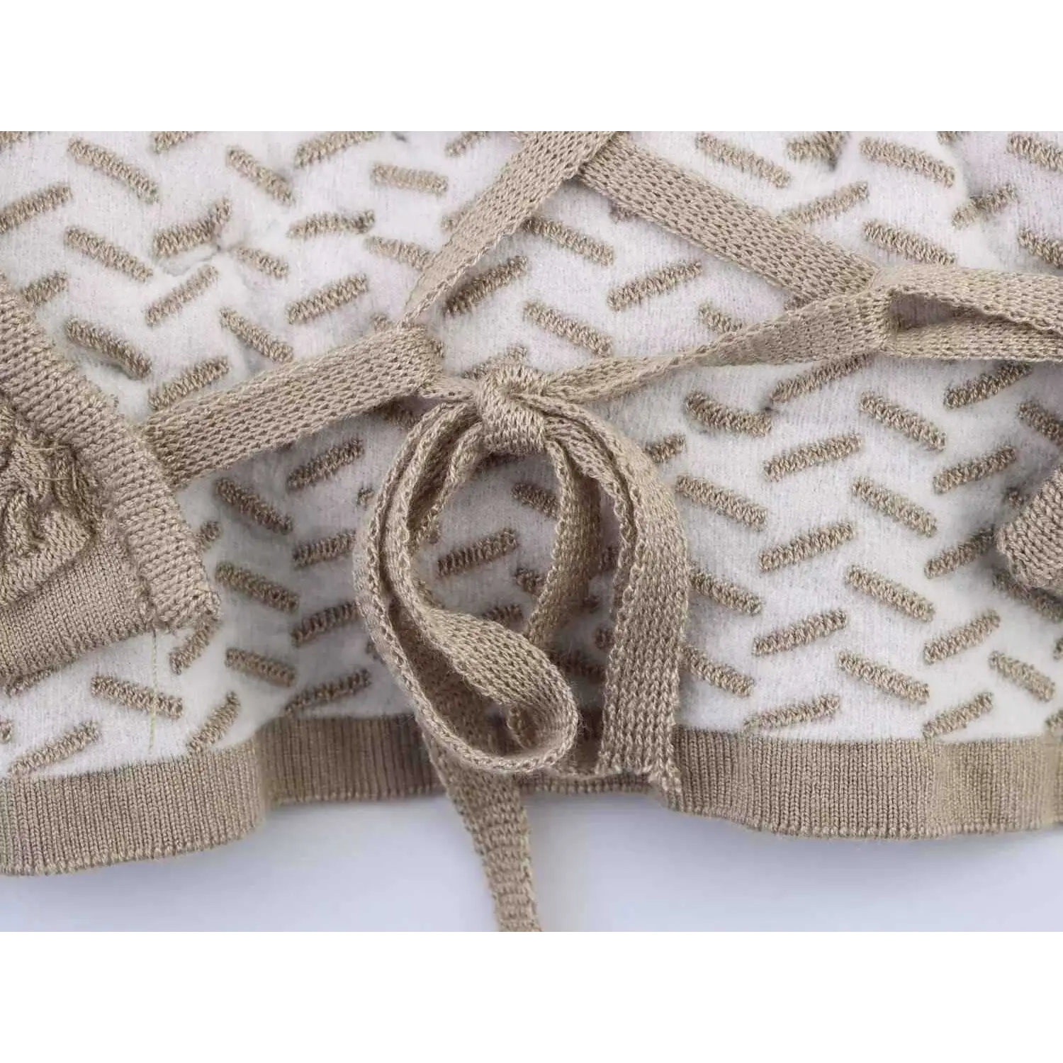  Close-up of the bottom lace-up tie knot on taupe cross-back camisole top