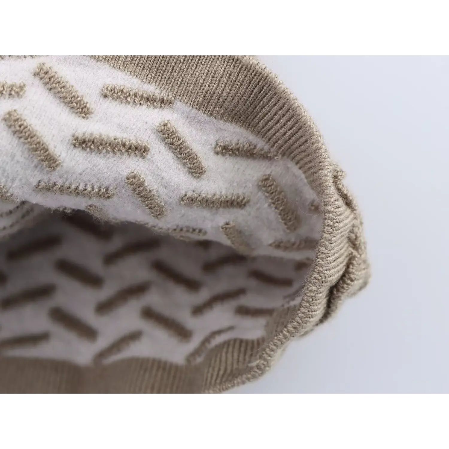 Close-up of the inner lining fabric showing the chevron knit pattern on taupe camisole top