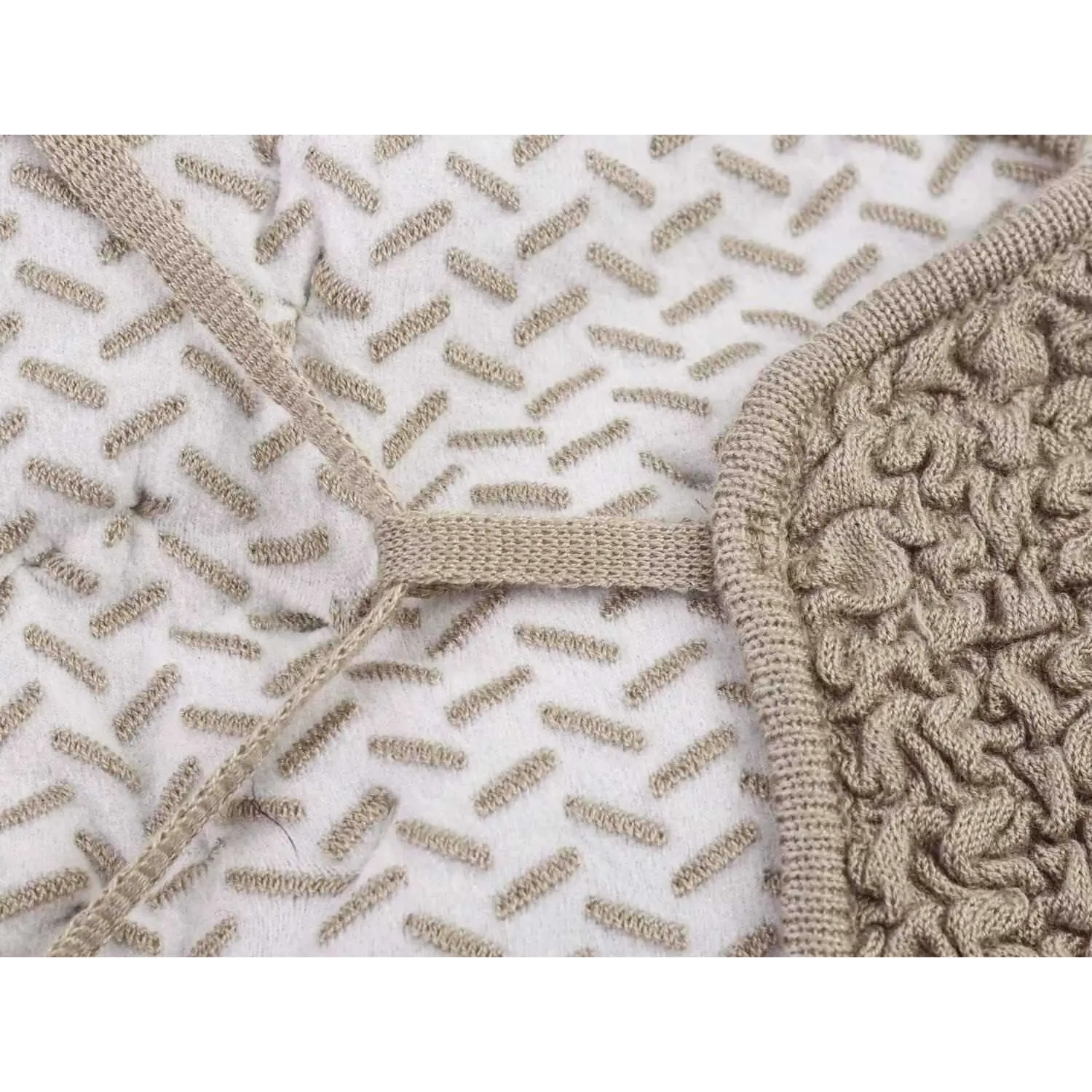 Close-up of side panel seam detail showing the textured bubble knit fabric and strap attachment