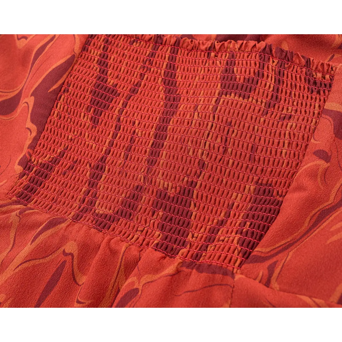 Close-up of dense red stitching elastic shirred back waistband on abstract floral print slip dress.