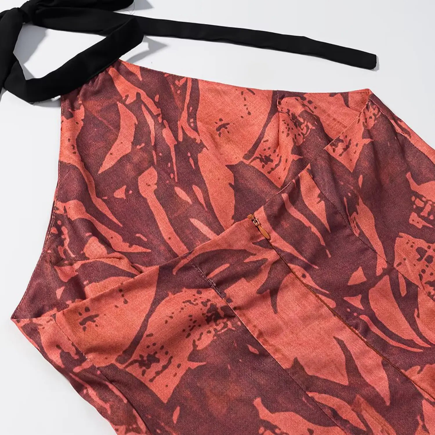 Close‑up view of invisible back zipper on terracotta floral halter midi dress