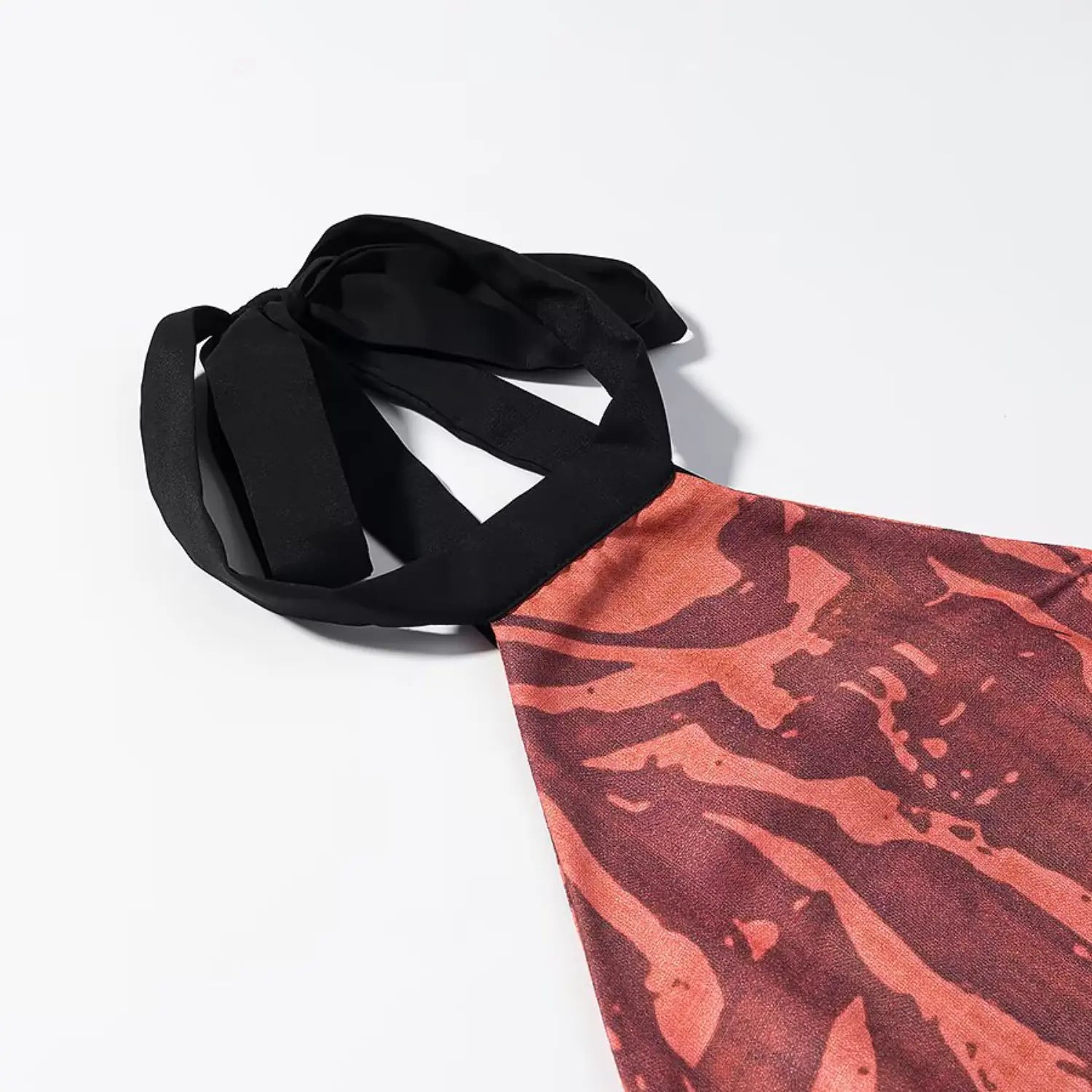 Close‑up detail of black fabric halter tie knot for terracotta floral print midi dress