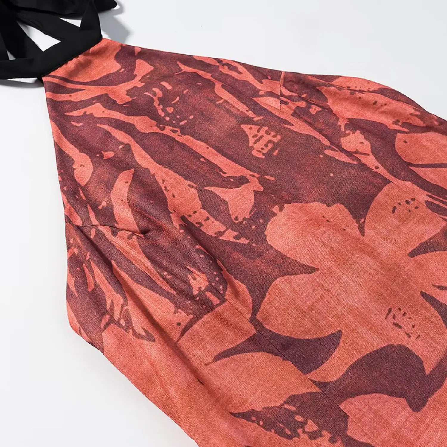 Macro shot of abstract floral print and woven fabric texture on halter midi dress bodice