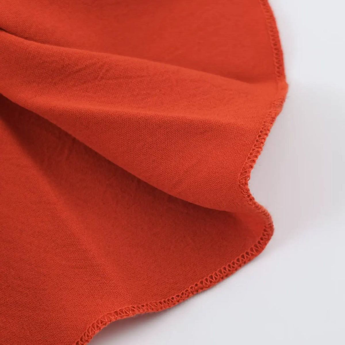 Close‑up of soft flowy terracotta pleated fabric texture