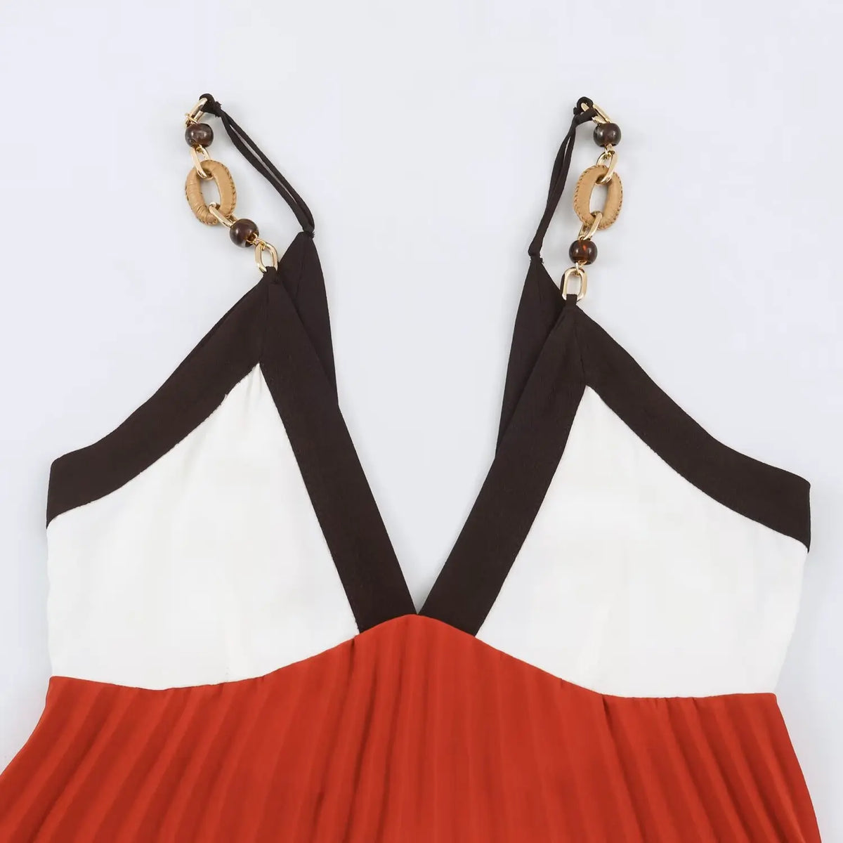 Close‑up of decorative metal chain spaghetti straps and color‑block bodice