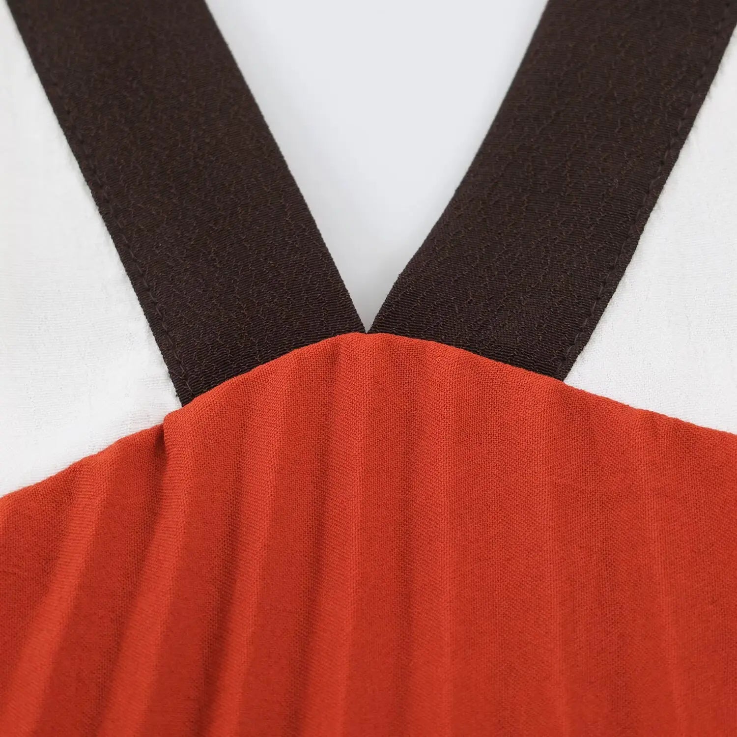 Detailed close‑up of v‑neck black trim terracotta‑white color‑block bodice