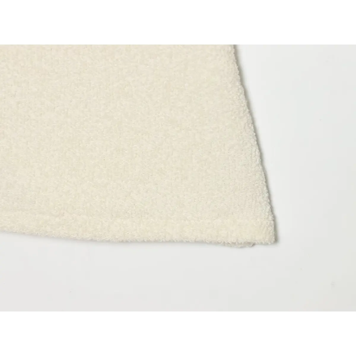 Bottom hem stitching close of soft cream terry cloth knit garment