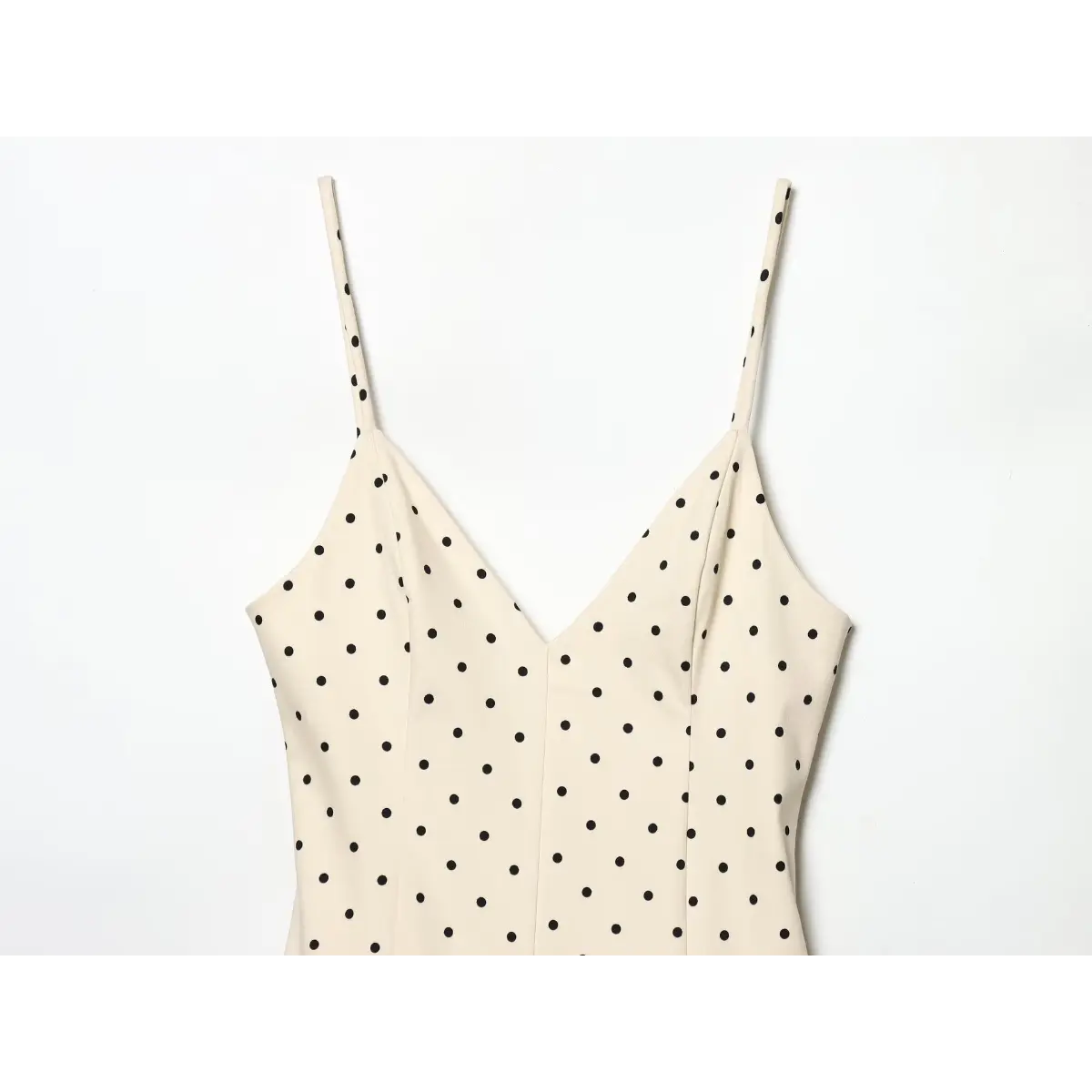 Top neck close of slim matching fabric shoulder straps, deep V tailored bust on classic polka dot sundress.