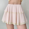 Model wearing a pink and beige tiered chiffon mini skirt, showing the flowy silhouette and how the layers drape naturally.