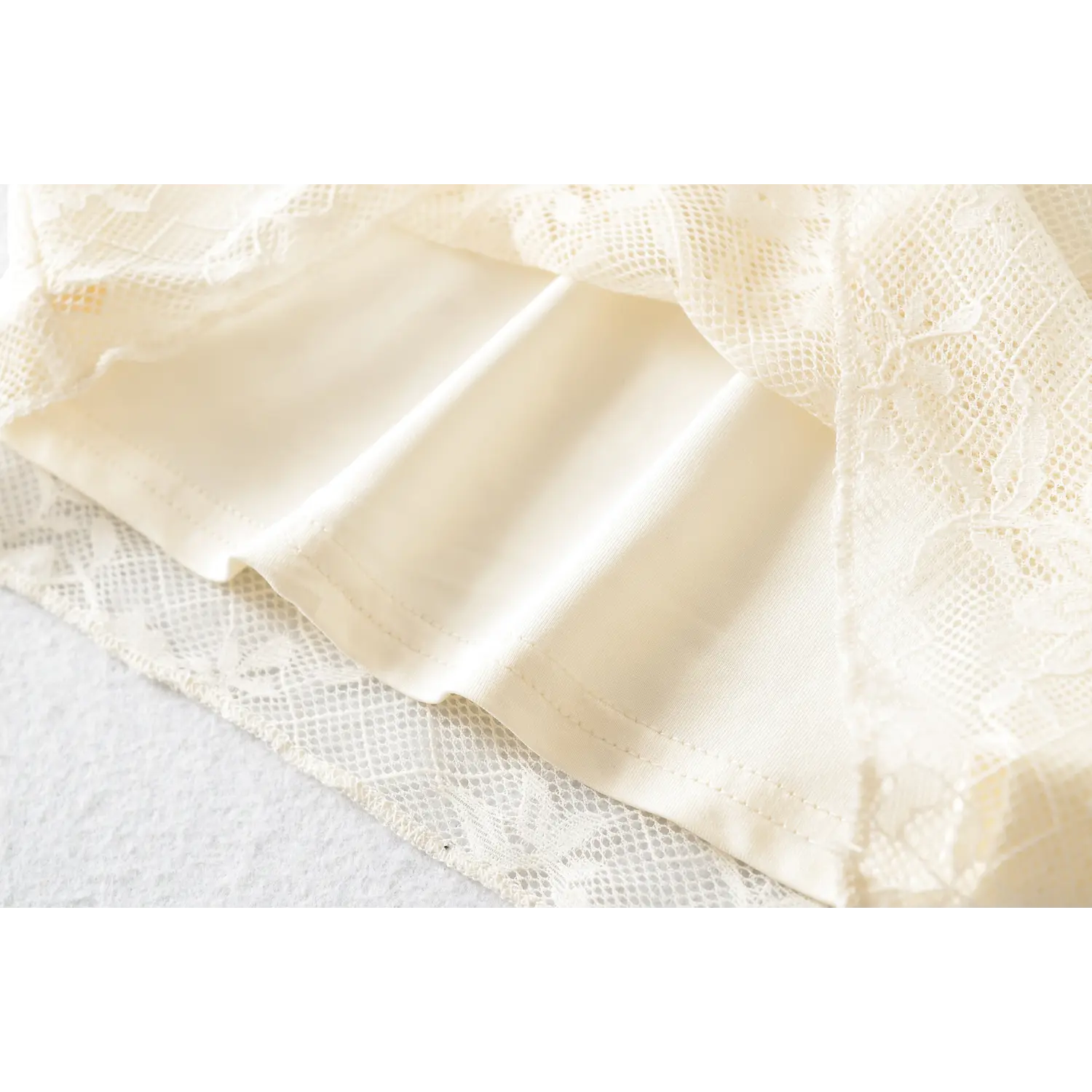 Top hem folded double lining macro close-up, outer floral lace, solid anti-see-through inner lining, even hem serging, double fabric drape texture shot