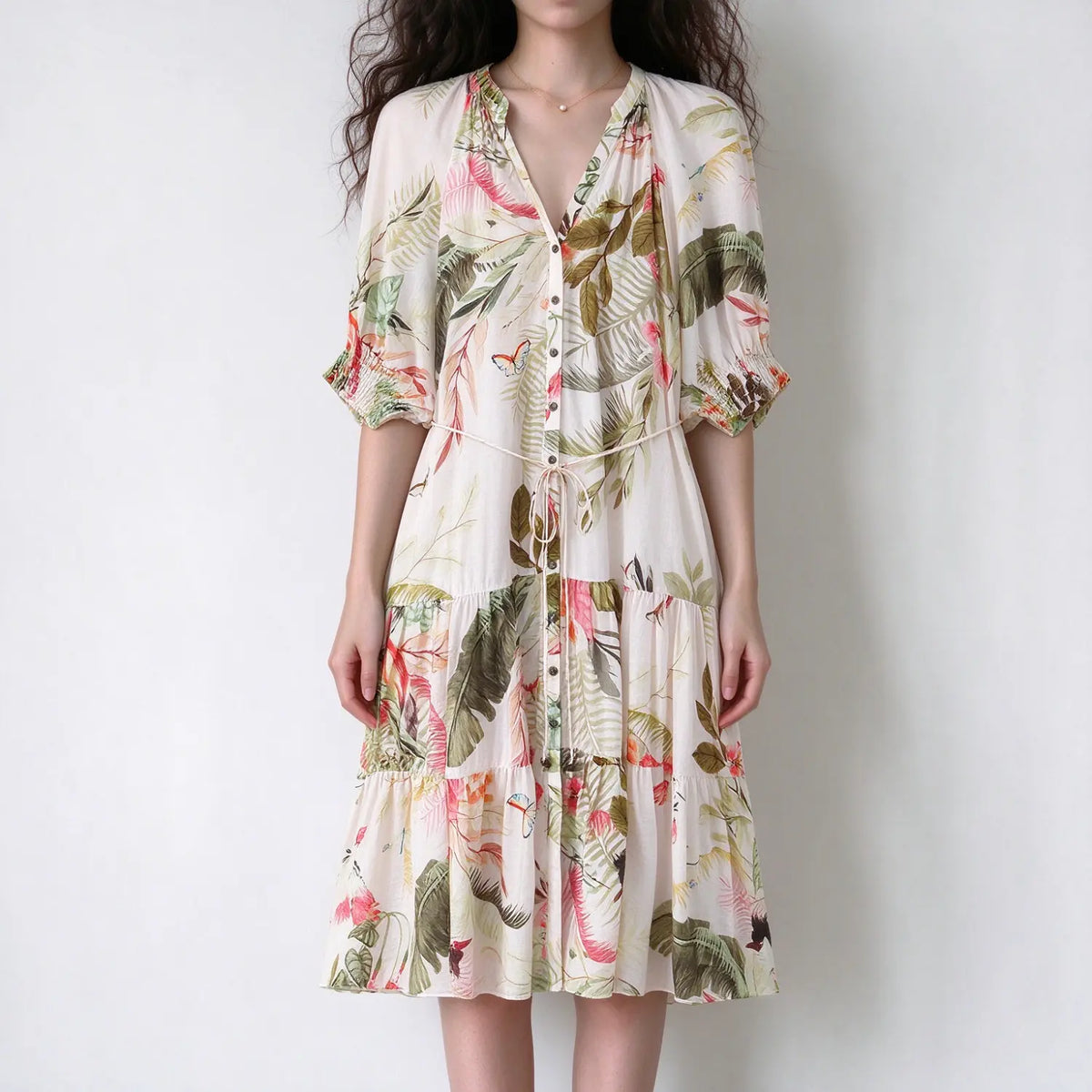 Female model front view wearing tropical leaf print midi dress, v neck, puff elbow sleeves, self drawstring waist, tiered long skirt