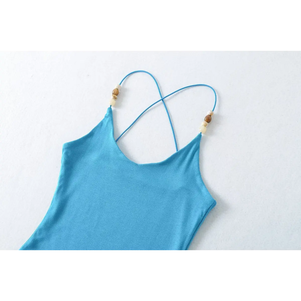 Close-up of the side hem stitching on the turquoise ribbed camisole top