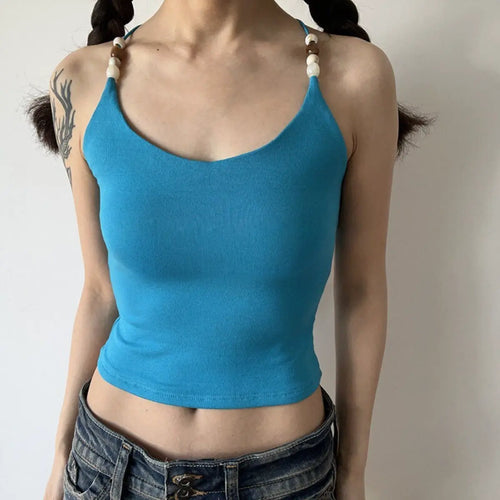 Lifestyle shot of turquoise ribbed camisole with beaded straps and crisscross back