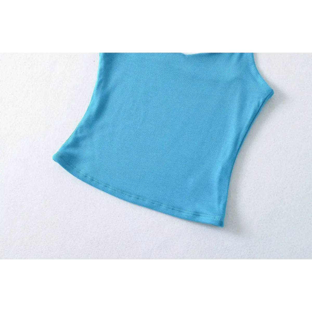 Close-up of the bottom hem and stitching on the turquoise ribbed camisole top