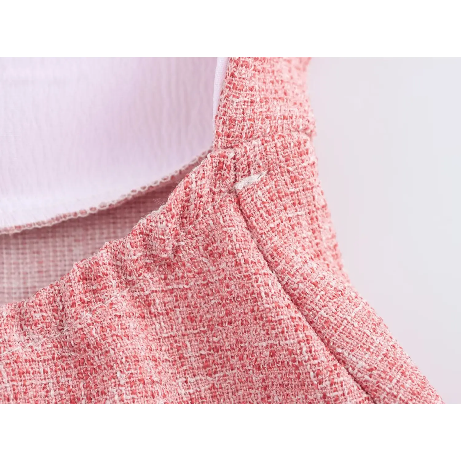 Torso partial shot, vertical tailored shaping darts, dense heather pink tweed weave, neat overlock stitching at lining junction