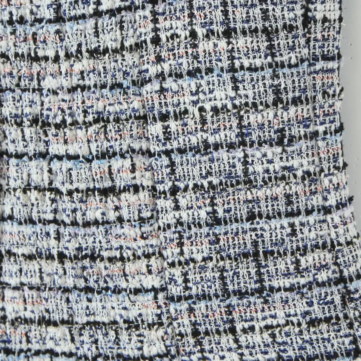 Close-up of the multi-color tweed fabric texture and woven pattern.