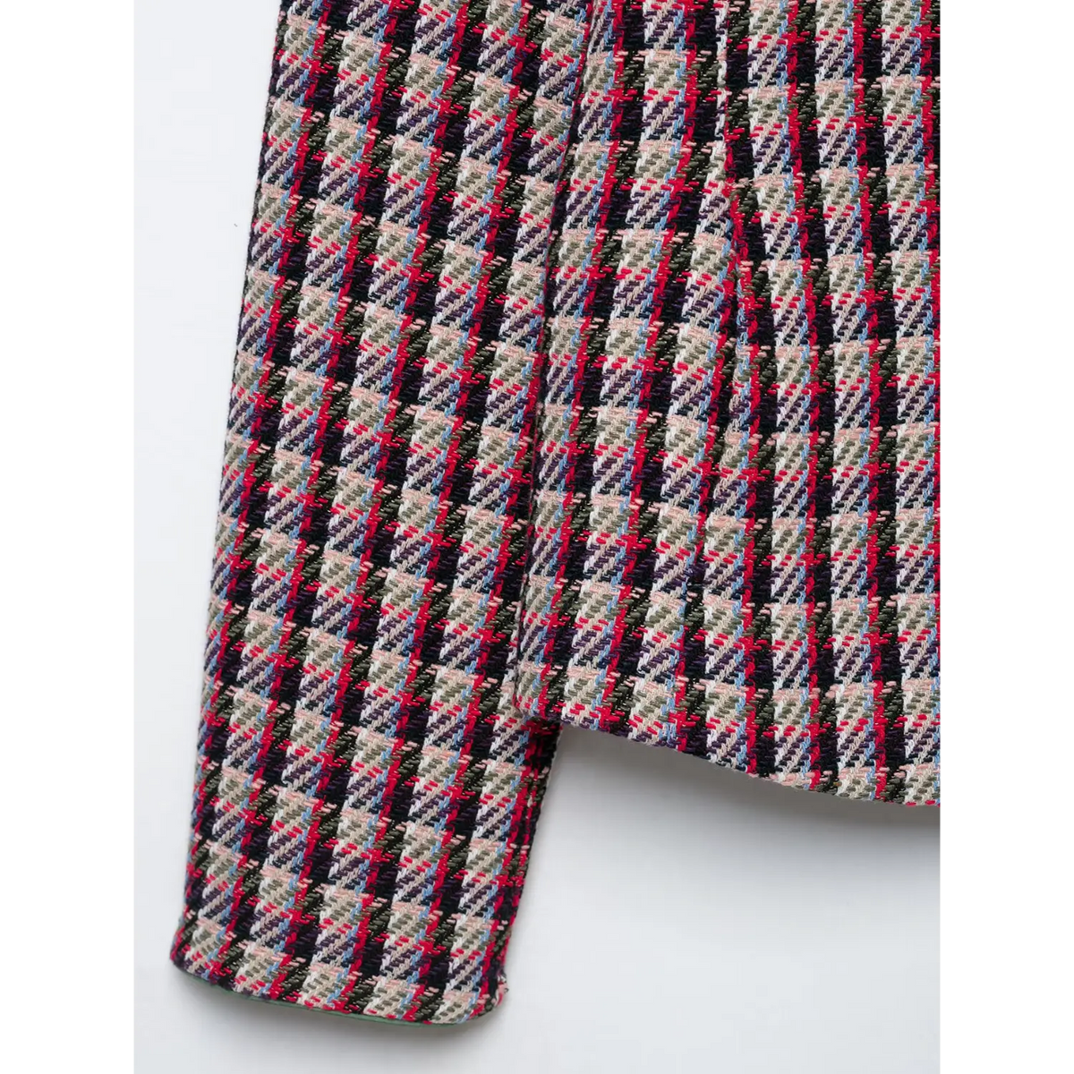 Close-up of multicolor houndstooth plaid tweed fabric in red, black and cream tones