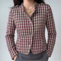 Model wearing plaid tweed stand collar jacket with pearl necklace and gray trousers